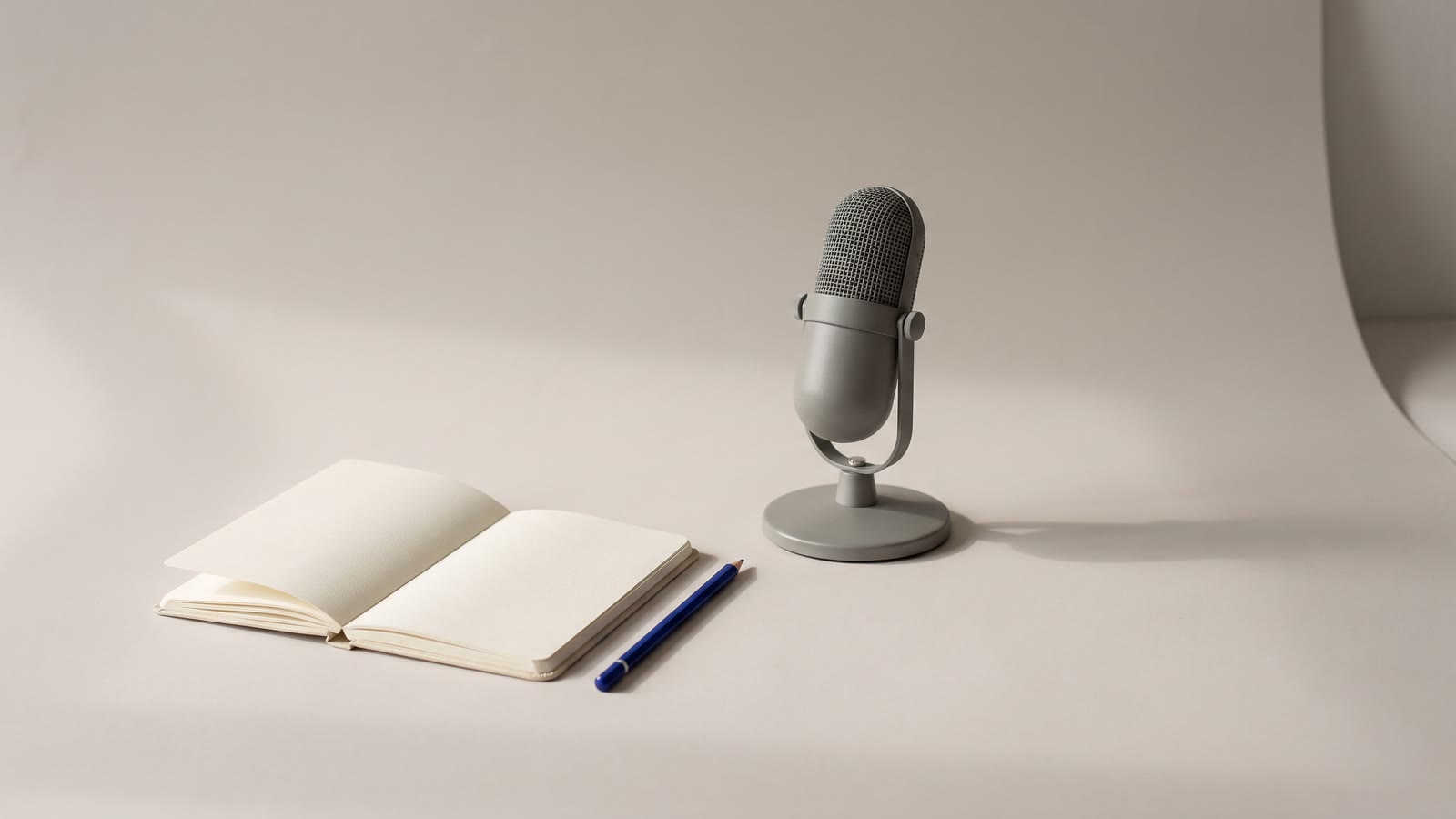 A microphone beside a blank notebook and pencil