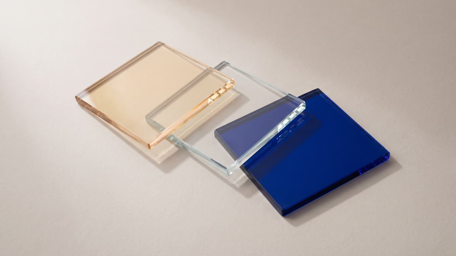 Three square glass colour filters fanned out, one amber, one clear, one blue