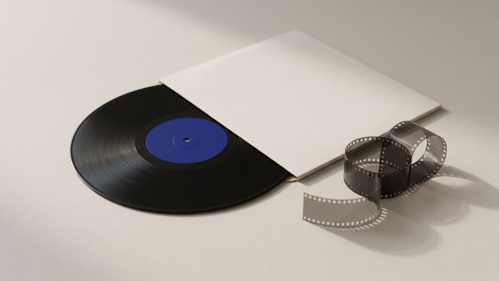 A vinyl record half out of its sleeve beside a film strip