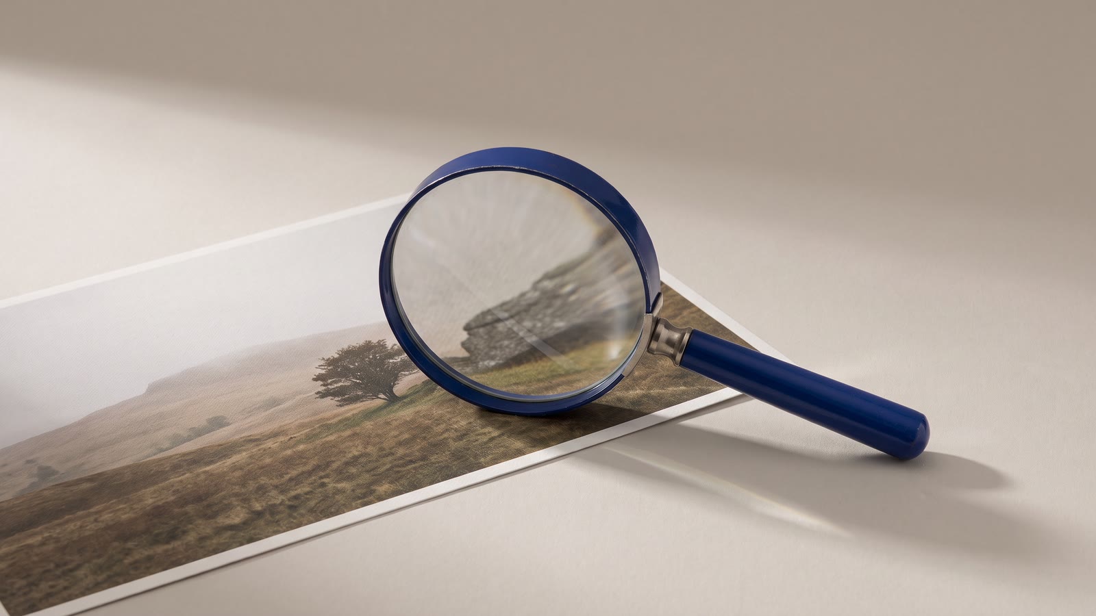 A magnifying glass resting on a photograph